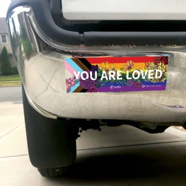 You Are Loved bumper sticker on a shiny metal car bumper